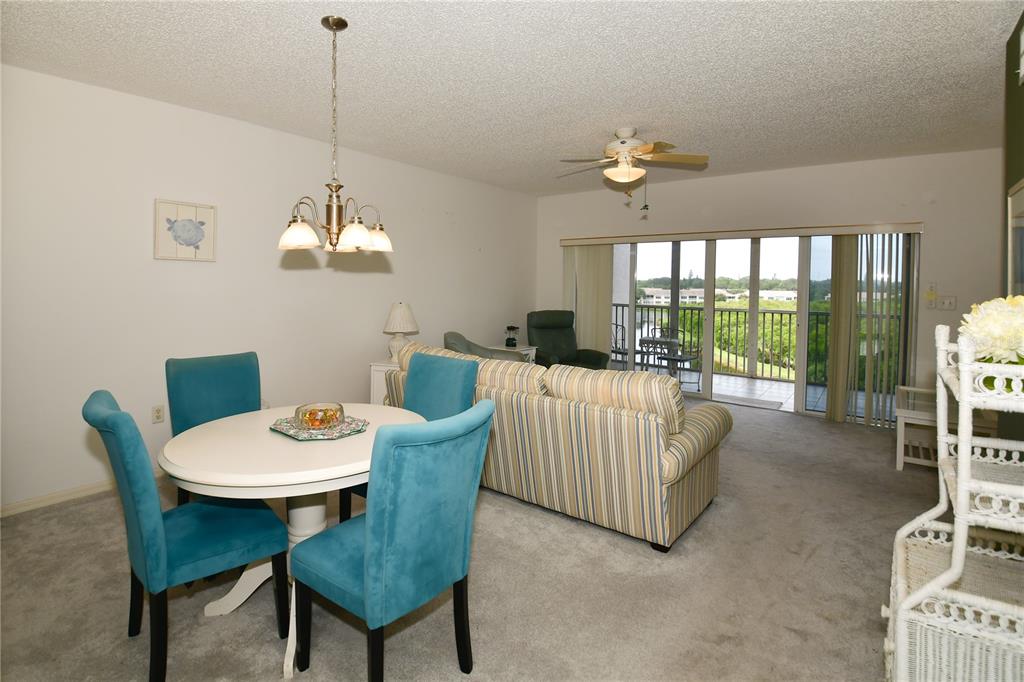 6450 Shoreline Drive, Unit 9405 St. Petersburg, FL 33708 - Photo 10 of 36 a living room with furniture a chandelier and a table