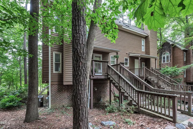 a view of house with a small yard and a large tree