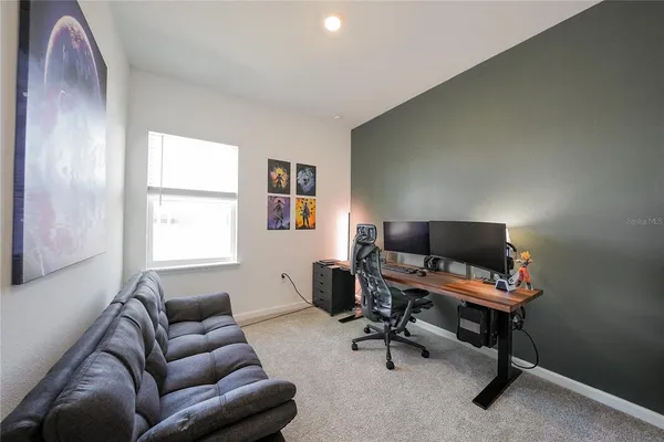a livingroom with workspace couch and a window