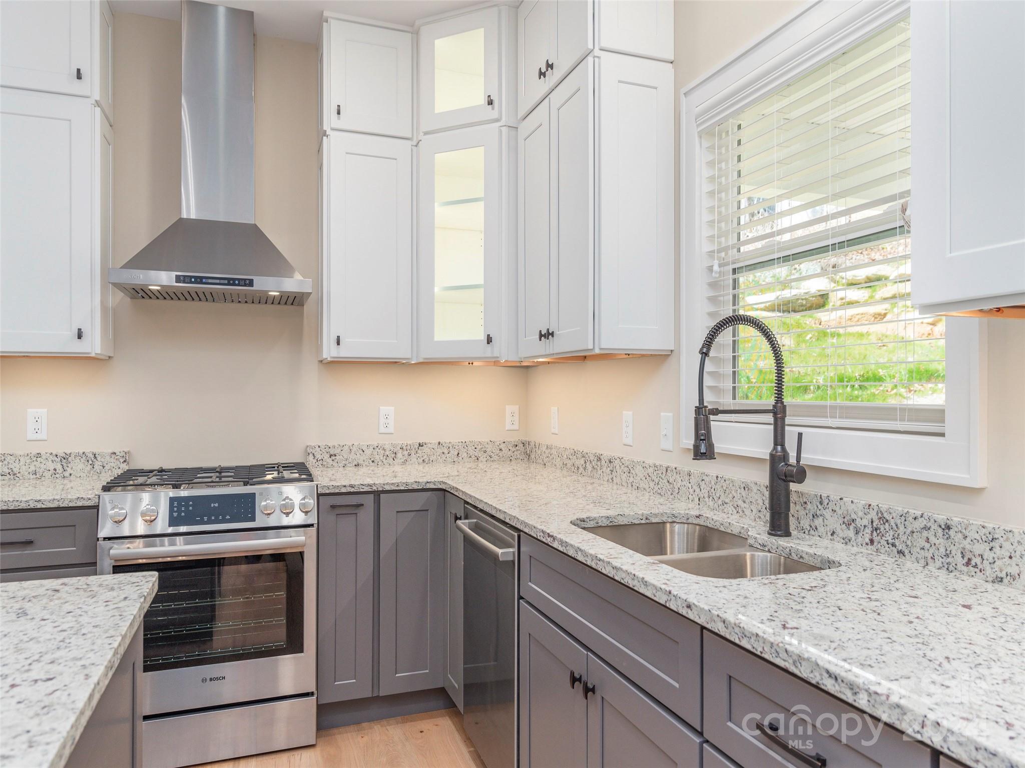 113 Millbrae Loop Hendersonville, NC 28791 - Photo 12 of 35 a kitchen with stainless steel appliances granite countertop a sink a stove and cabinets