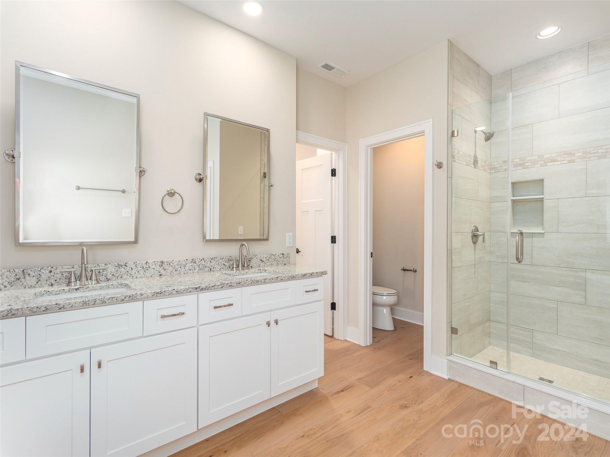 113 Millbrae Loop Hendersonville, NC 28791 - Photo 16 of 35 a bathroom with a granite countertop sink mirror and a shower