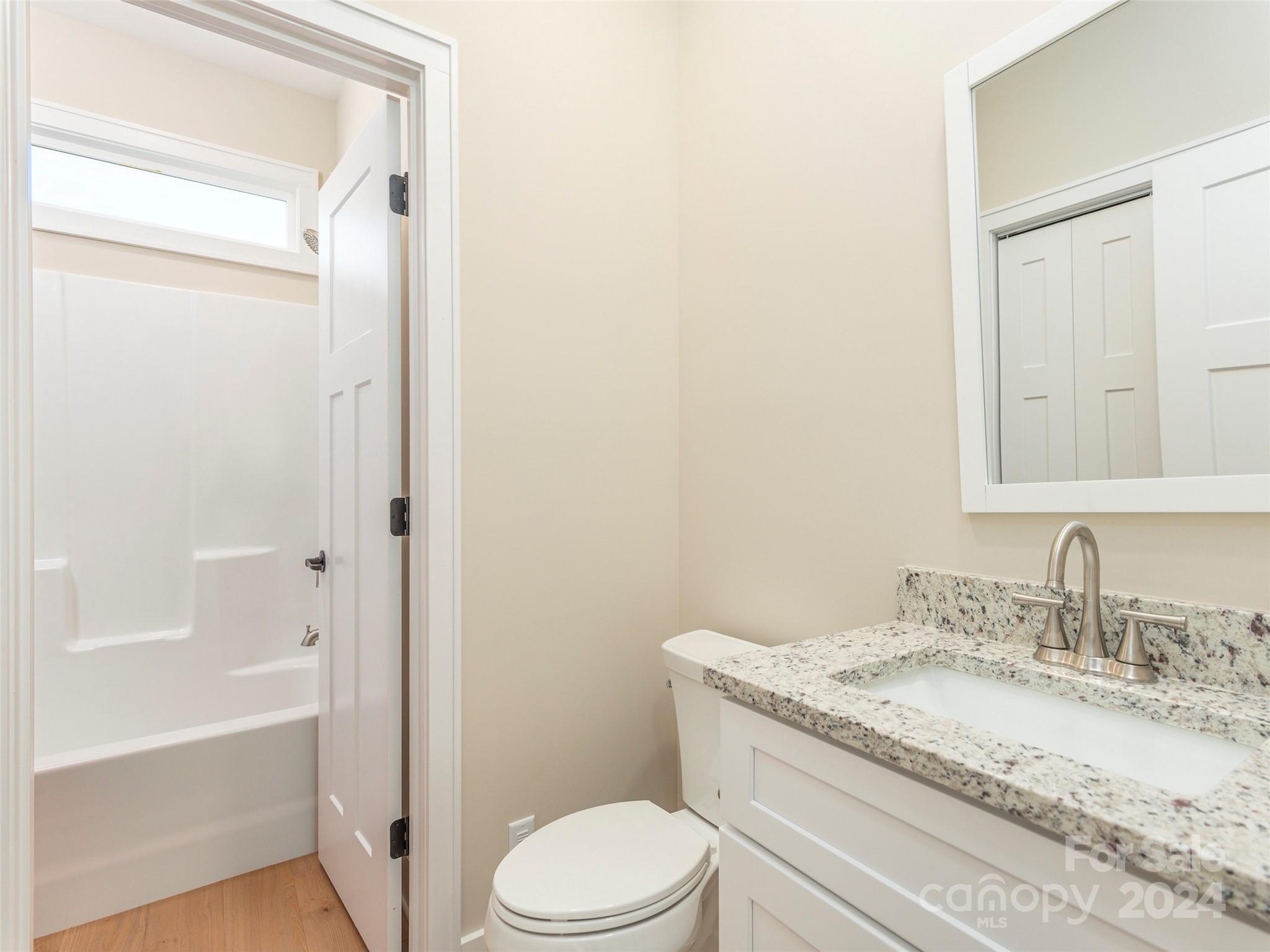 113 Millbrae Loop Hendersonville, NC 28791 - Photo 23 of 35 a bathroom with a granite countertop toilet a sink and a bathtub