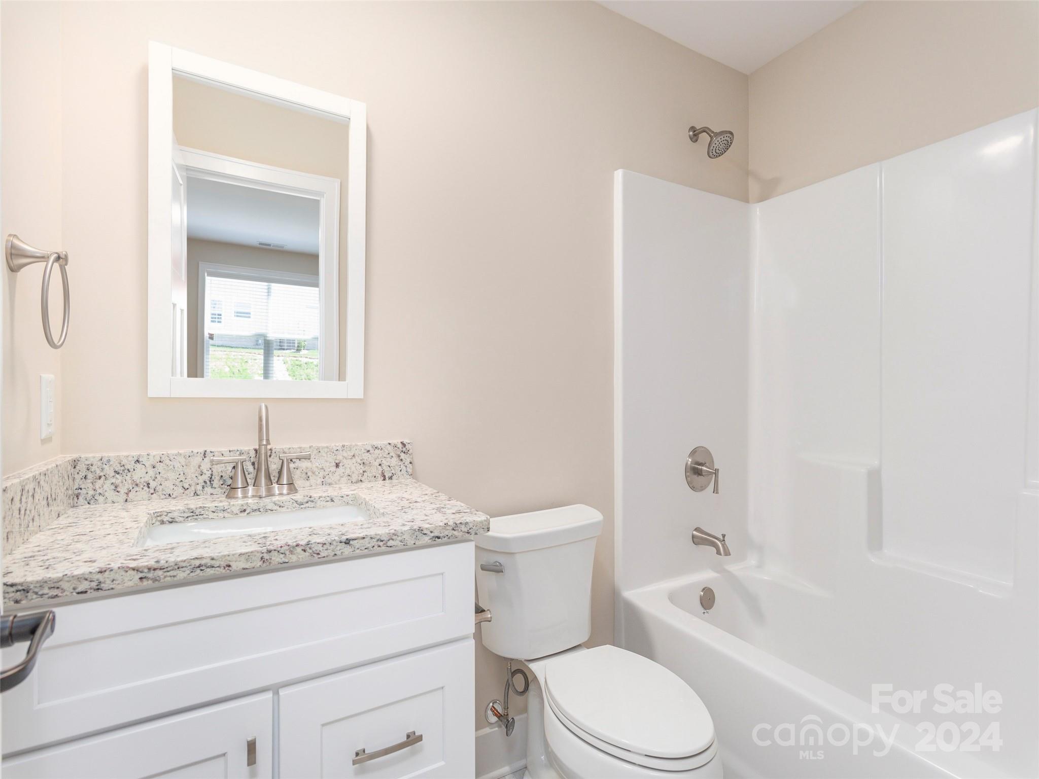113 Millbrae Loop Hendersonville, NC 28791 - Photo 25 of 35 a bathroom with a granite countertop toilet a sink and a bathtub