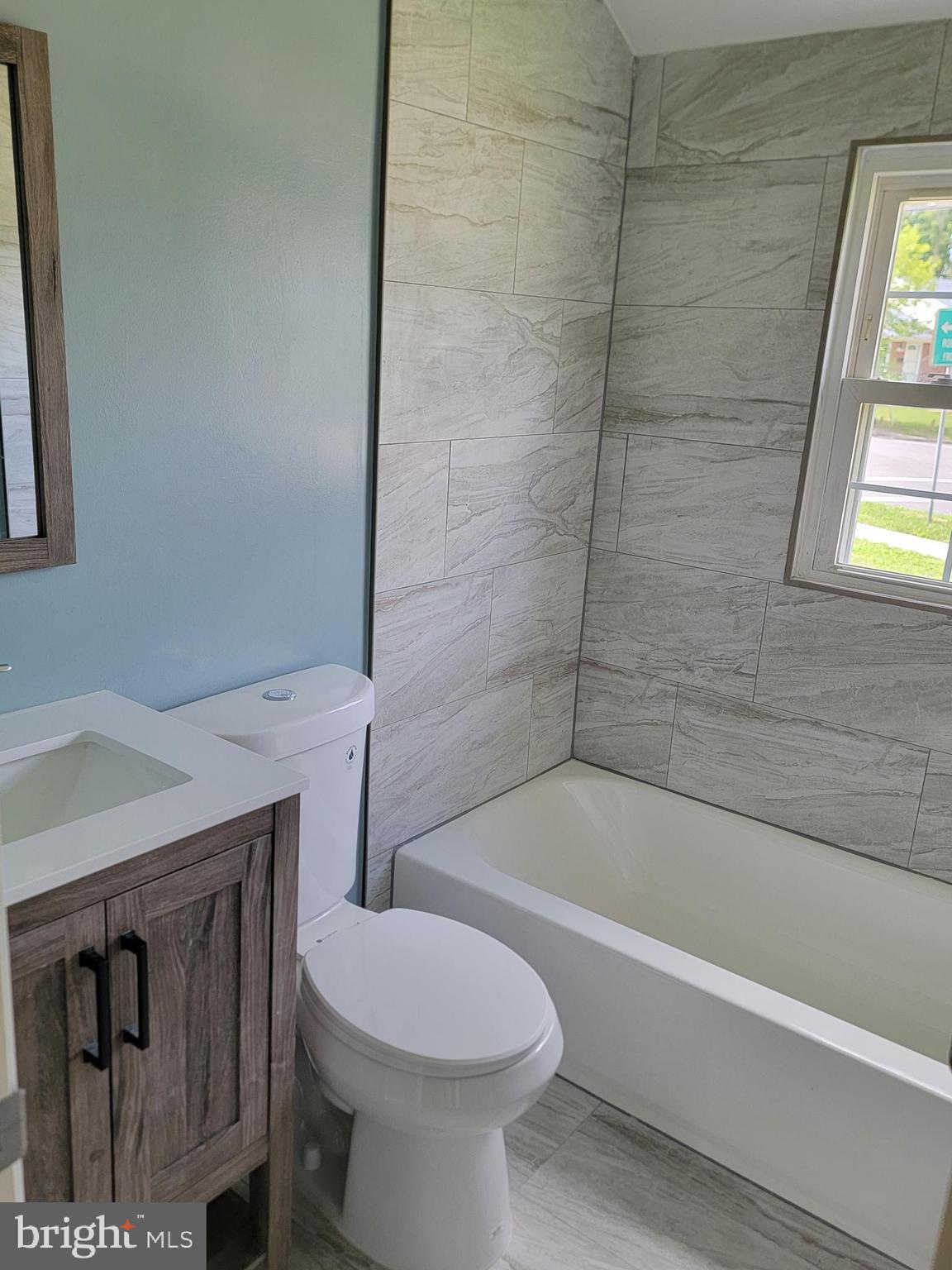 8300 Cathedral Avenue New Carrollton, MD 20784 - Photo 14 of 43 a bathroom with a sink a toilet and bathtub
