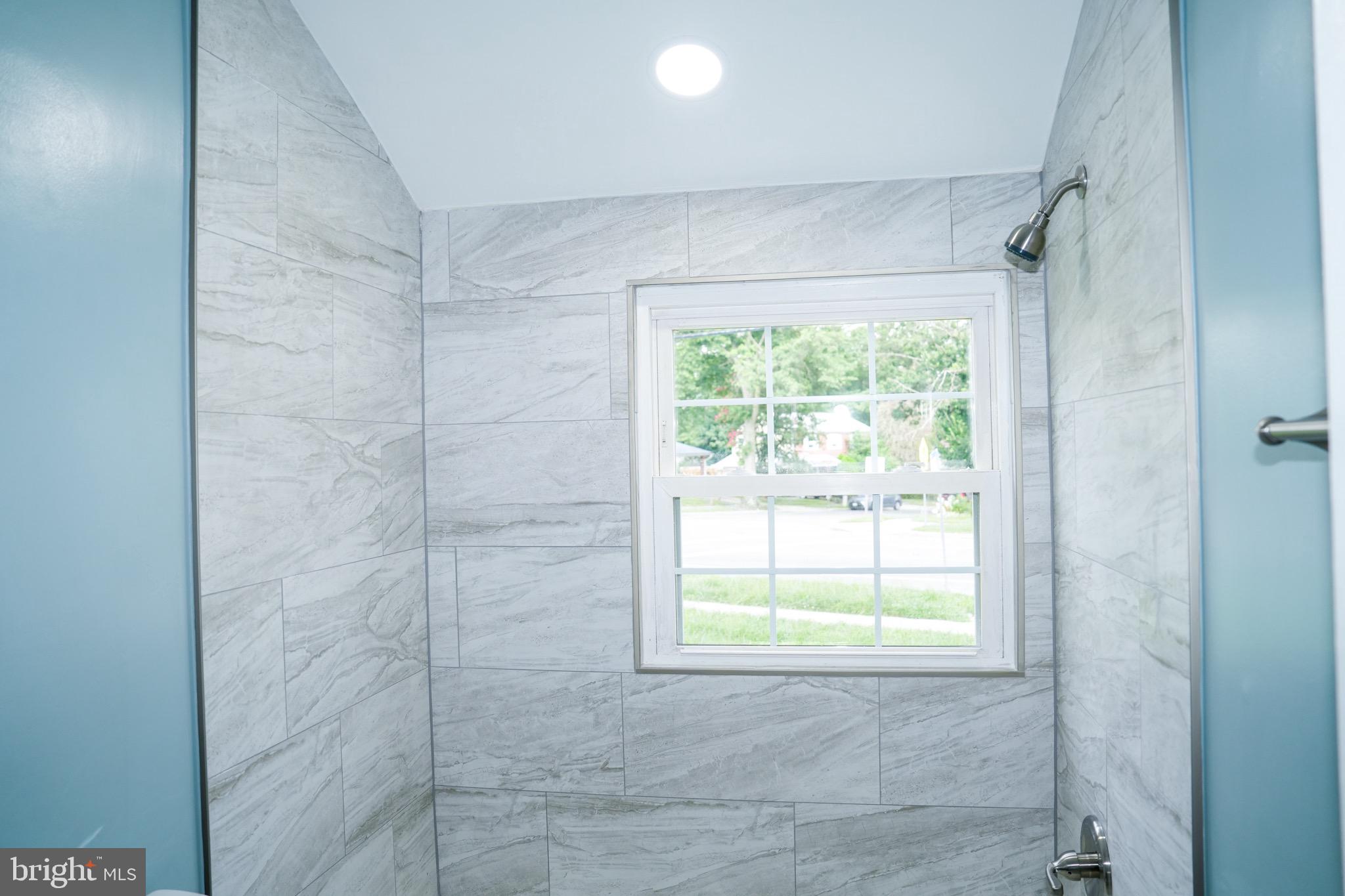 8300 Cathedral Avenue New Carrollton, MD 20784 - Photo 32 of 43 a bathroom with a window and shower