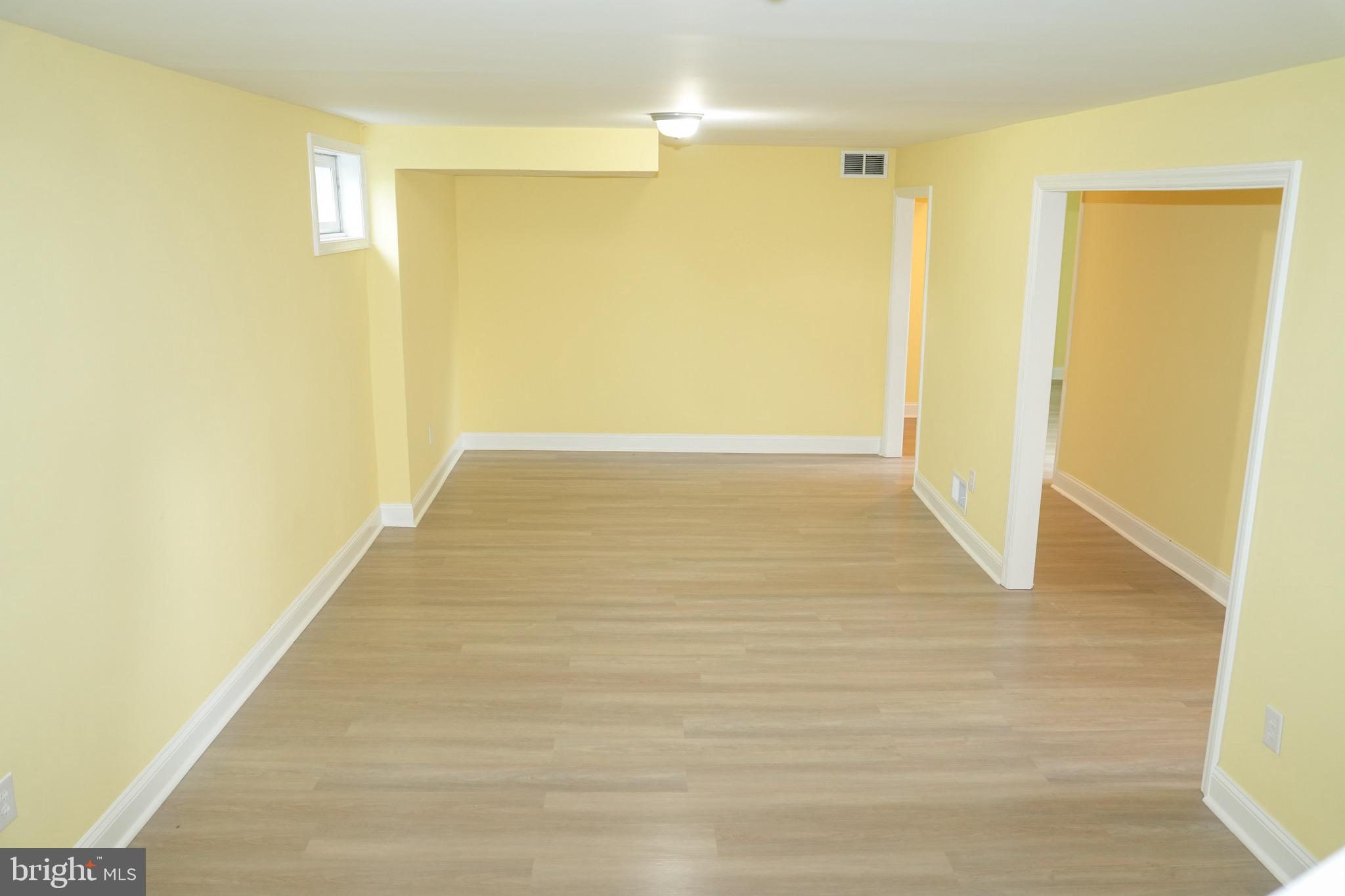 8300 Cathedral Avenue New Carrollton, MD 20784 - Photo 41 of 43 a view of an empty room with wooden floor and a window