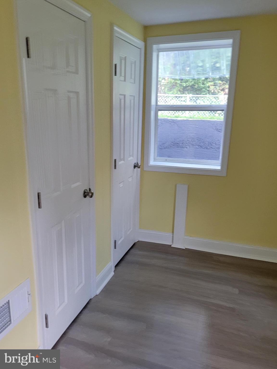 8300 Cathedral Avenue New Carrollton, MD 20784 - Photo 5 of 43 a view of an empty room with wooden floor and a window