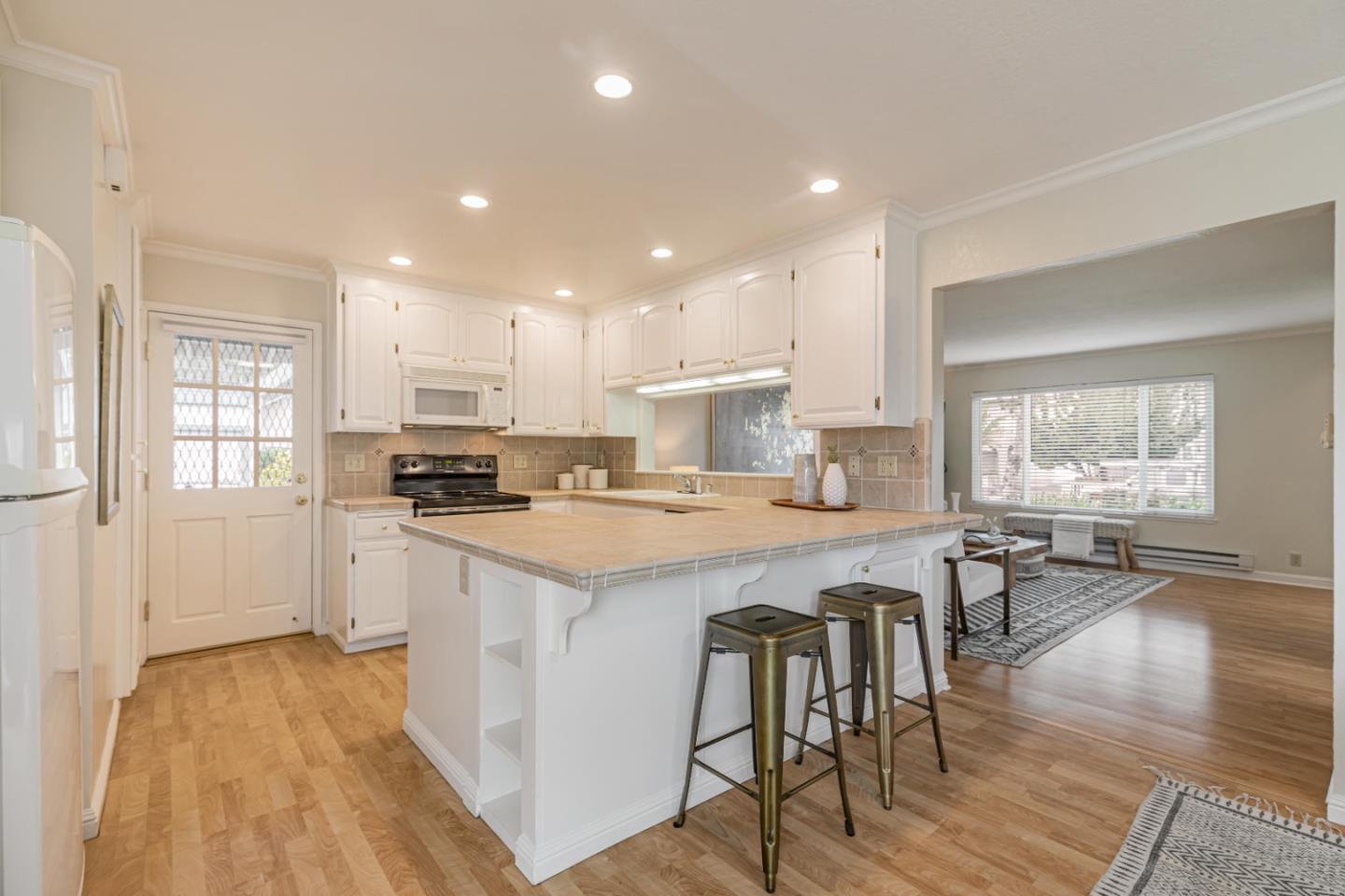 1298 Reeve Street Santa Clara, CA 95050 - Photo 15 of 28 a kitchen with a sink a stove a refrigerator and island with wooden floor