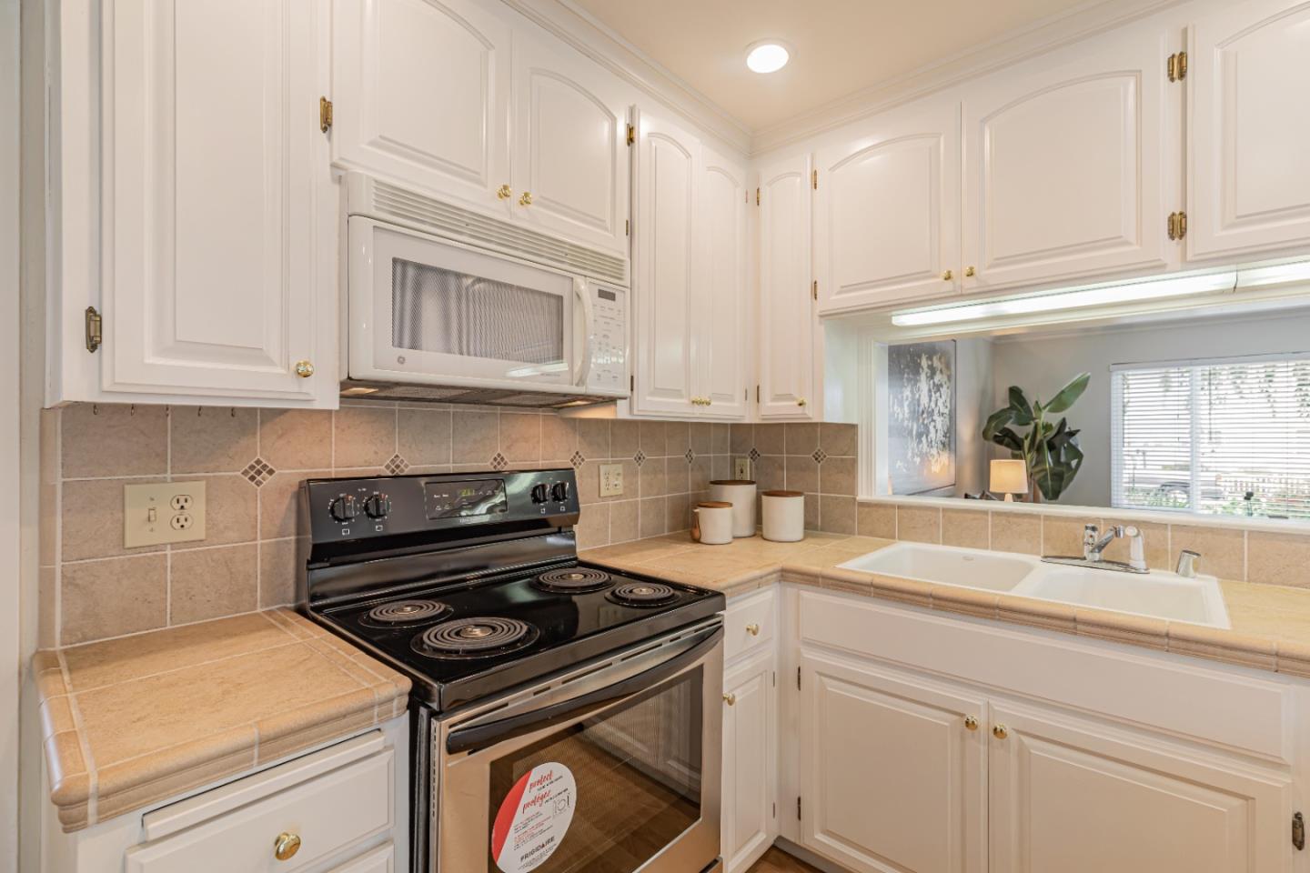 1298 Reeve Street Santa Clara, CA 95050 - Photo 18 of 28 a kitchen with granite countertop white cabinets and white appliances