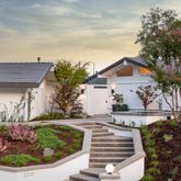 a view of a house with a small yard and potted plants