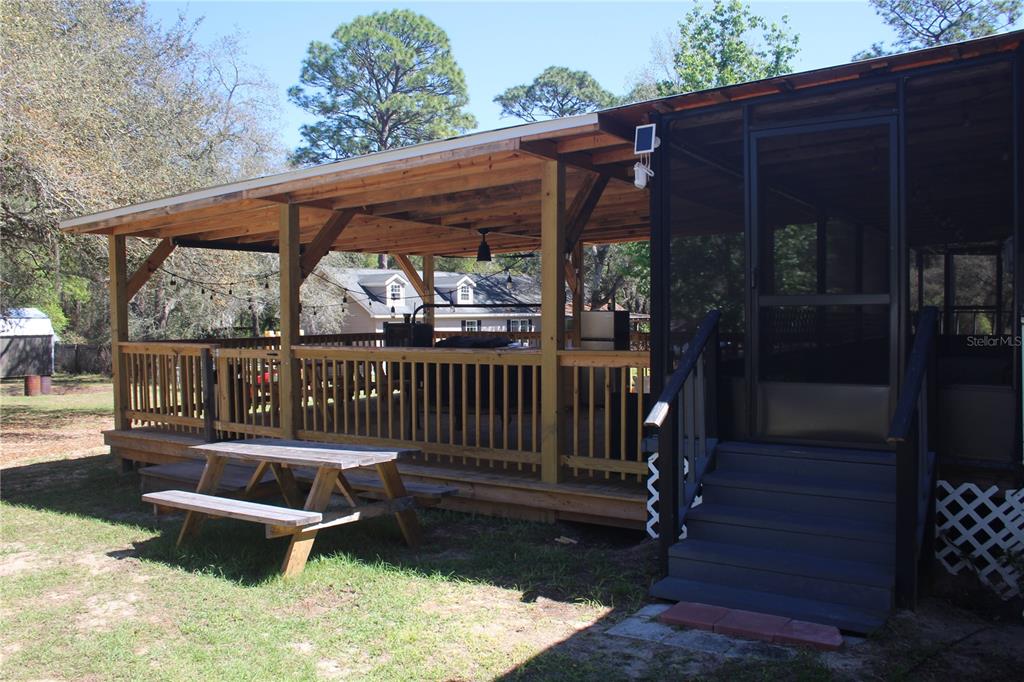 24427 Wild Turkey Road Paisley, FL 32767 - Photo 12 of 55 a view of a chair and tables in backyard of the house