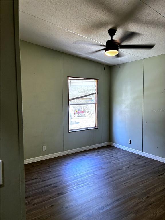 24427 Wild Turkey Road Paisley, FL 32767 - Photo 18 of 55 an empty room with wooden floor chandelier fan and windows