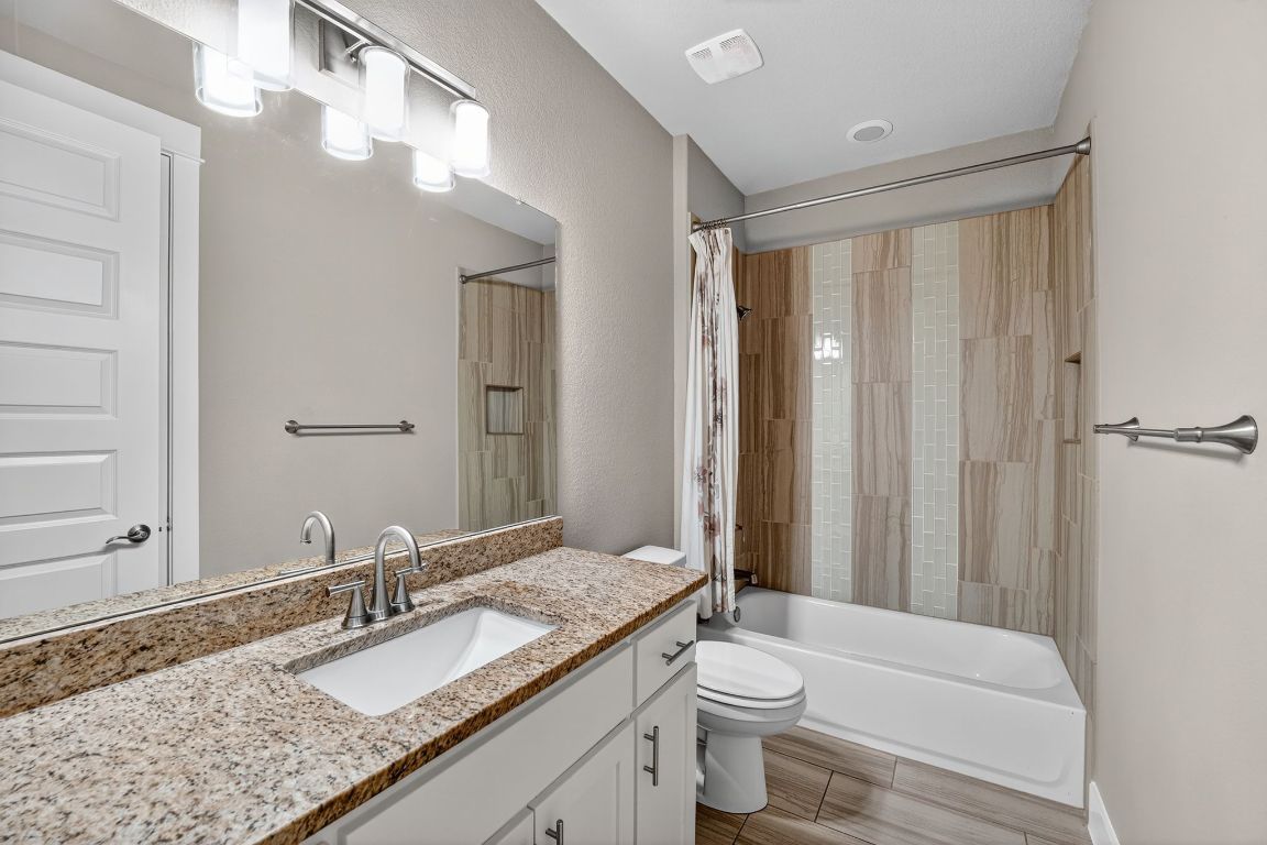 112 Sweetleaf Cove Georgetown, TX 78633 - Photo 20 of 28 a bathroom with a granite countertop sink toilet and shower