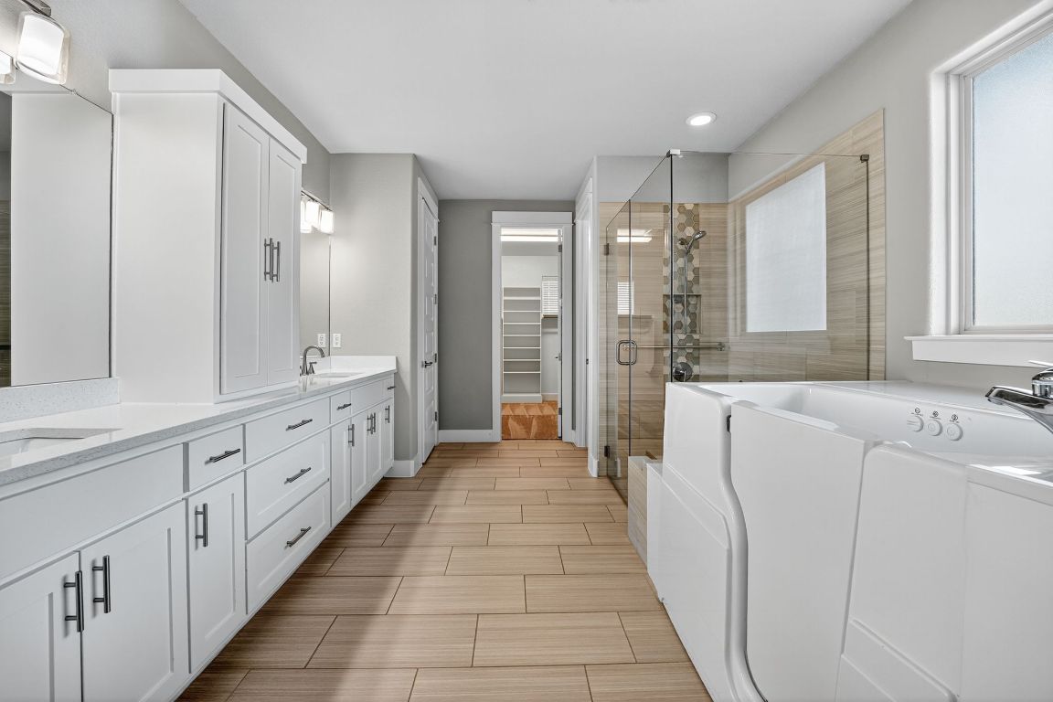 112 Sweetleaf Cove Georgetown, TX 78633 - Photo 21 of 28 a bathroom with a double vanity sink and mirror with shower
