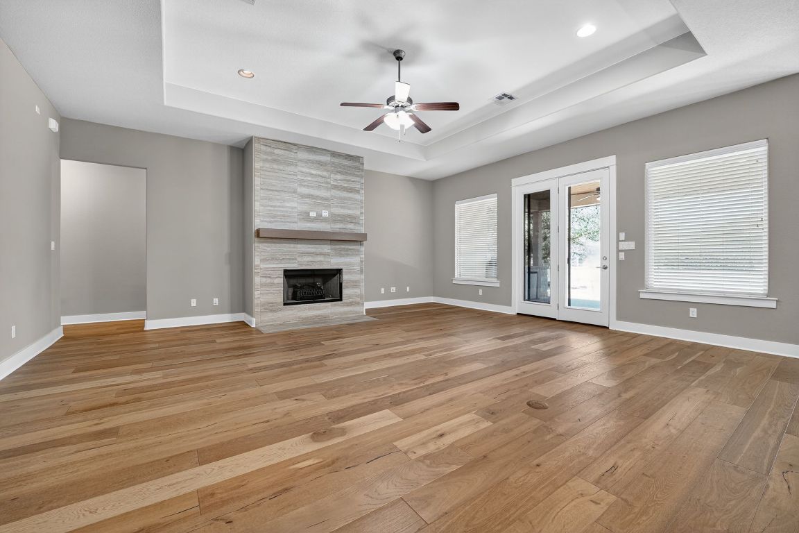 112 Sweetleaf Cove Georgetown, TX 78633 - Photo 10 of 28 a view of an empty room with wooden floor fireplace and a window