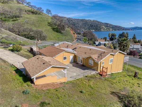 a aerial view of a house with a yard and palm trees