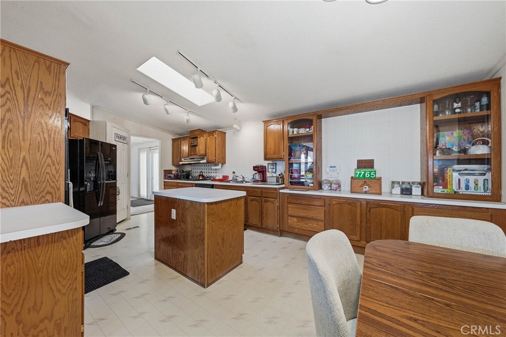 7765 Verna Way Lucerne, CA 95458 - Photo 10 of 37 a kitchen with stainless steel appliances granite countertop a refrigerator a sink dishwasher a dining table and chairs with wooden floor