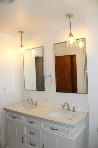 a bathroom with double sink and a mirror