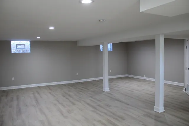an empty room with wooden floor and door