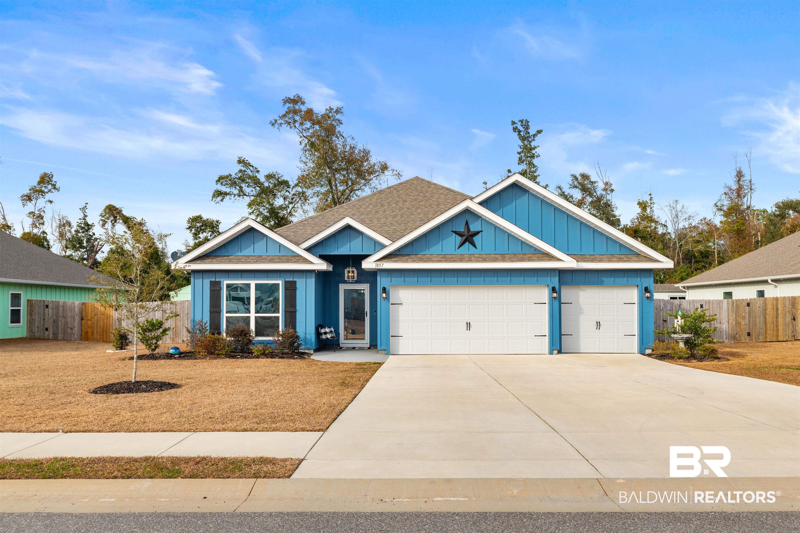 1857 Carly Street Foley, AL 36535 - Photo 1 of 42 View of front facade with a garage, a shingled roof, concrete driveway, fence, and board and batten siding