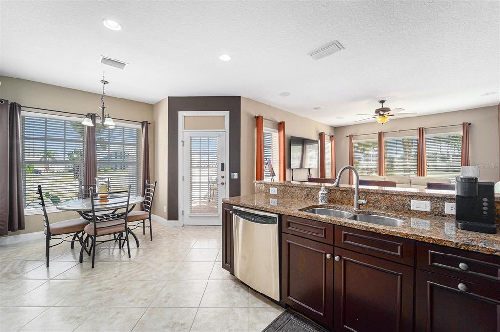 5516 Luminar Pointe Lane Apollo Beach, FL 33572 - Photo 15 of 34 a open kitchen with granite countertop a sink and chairs