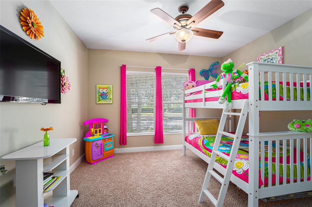 5516 Luminar Pointe Lane Apollo Beach, FL 33572 - Photo 16 of 34 a bedroom with furniture a flat screen tv and a bed