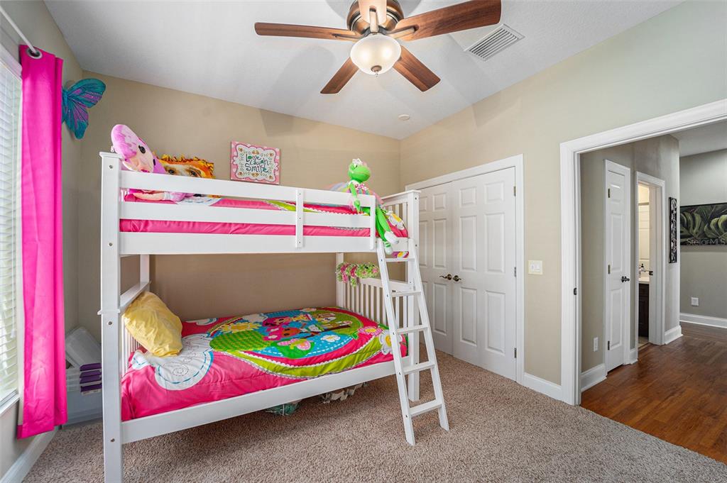 5516 Luminar Pointe Lane Apollo Beach, FL 33572 - Photo 17 of 34 a bedroom with a bed and a chandelier