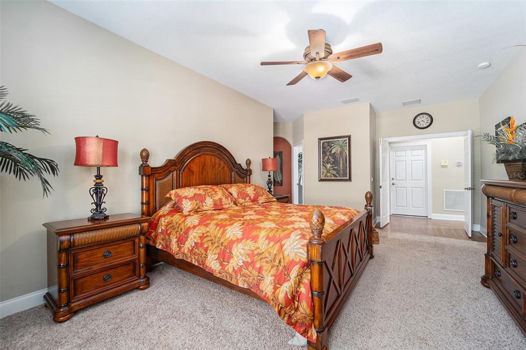 5516 Luminar Pointe Lane Apollo Beach, FL 33572 - Photo 23 of 34 a bedroom with a bed and a ceiling fan