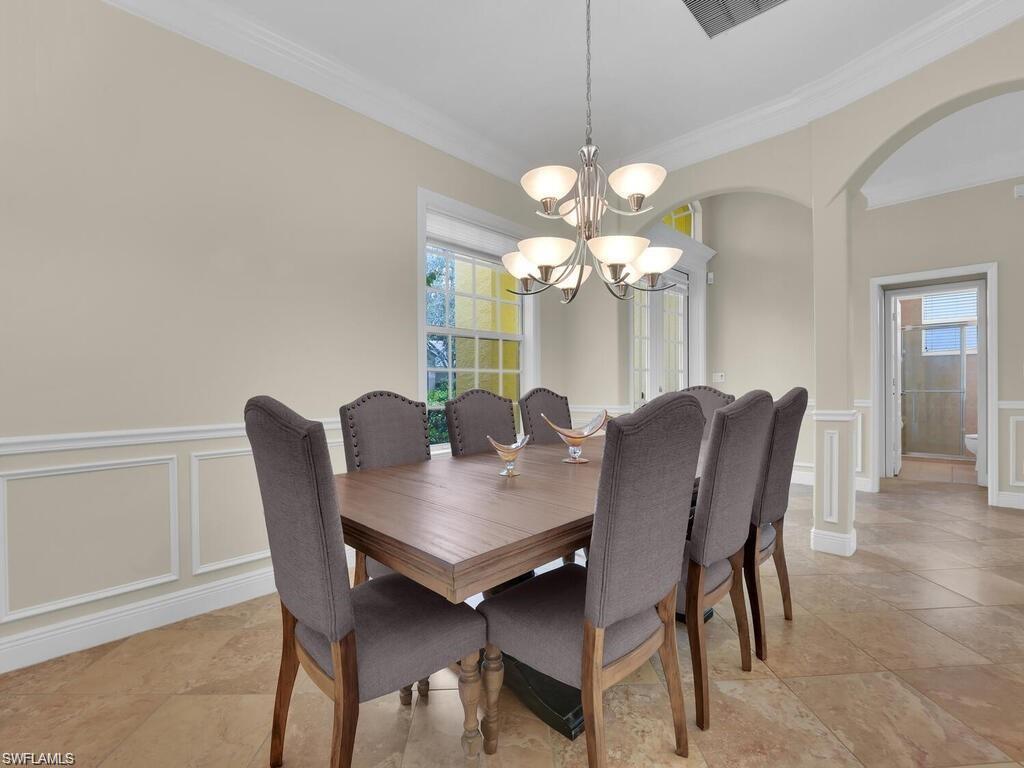 9983 Colonial Walk North Estero, FL 33928 - Photo 14 of 39 a view of a dining room with furniture and chandelier