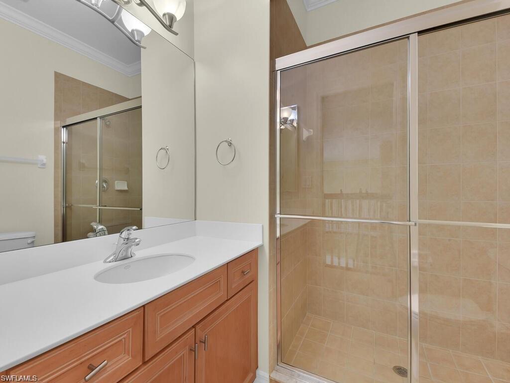 9983 Colonial Walk North Estero, FL 33928 - Photo 25 of 39 a bathroom with a shower sink vanity and a mirror