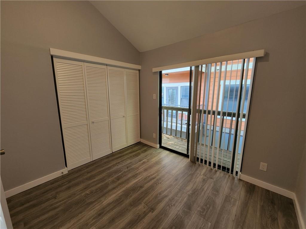 2815 Rio Grande Street, Unit 215 Austin, TX 78705 - Photo 7 of 11 A private balcony offers outdoor relaxation from this comfortable bedroom with wood-look flooring.