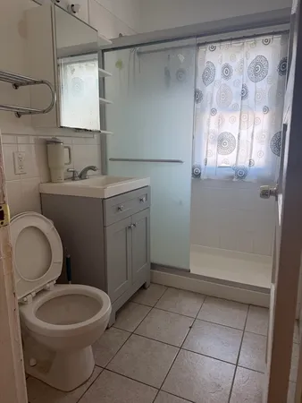 a bathroom with a toilet sink a mirror and shower