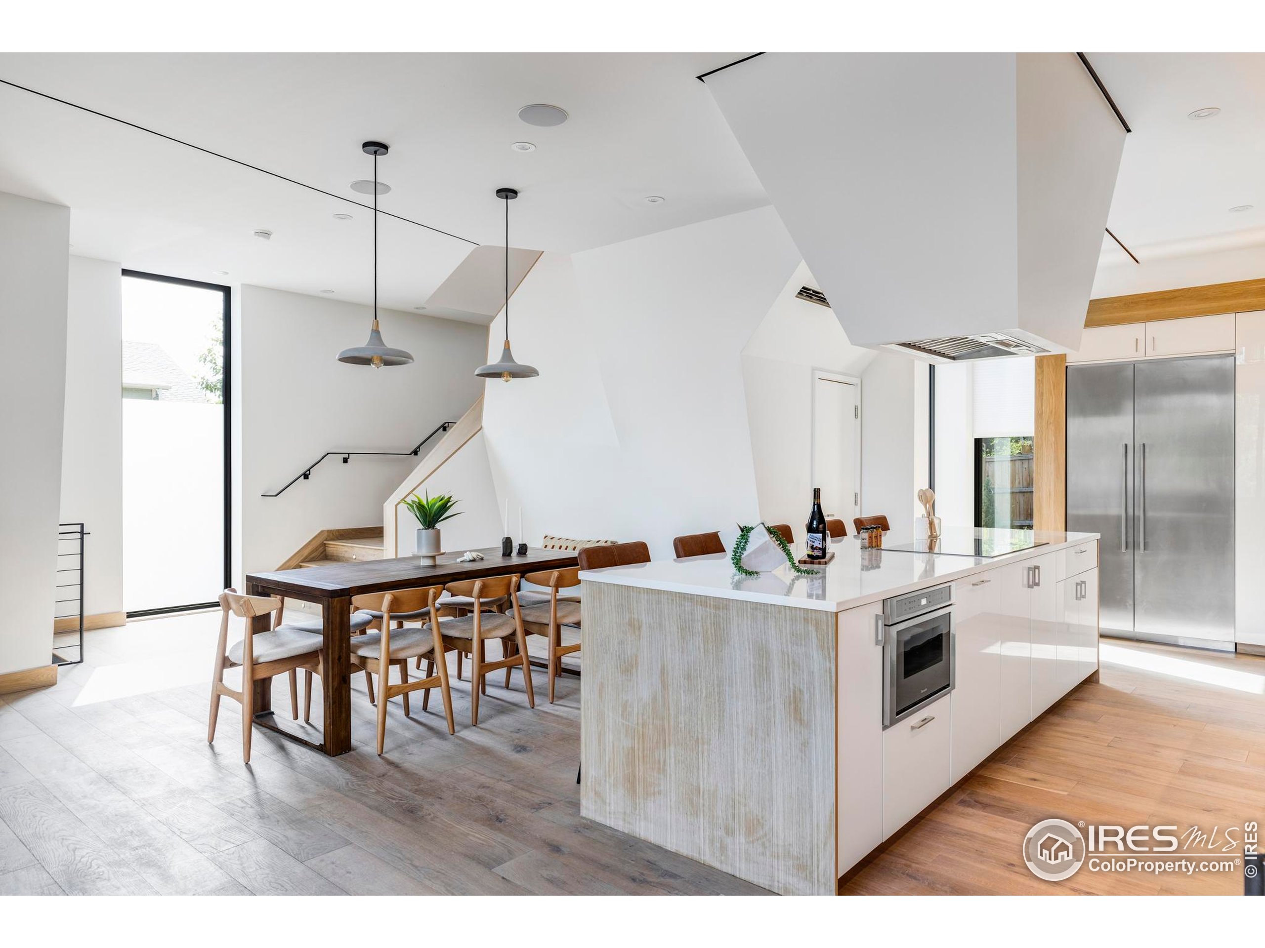 944 Arapahoe Avenue, Unit A Boulder, CO 80302 - Photo 11 of 36 a kitchen with a stove a refrigerator and a dining table with wooden floor