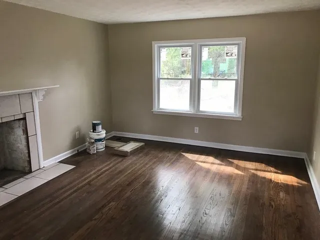 a view of a room with wooden floor and a window