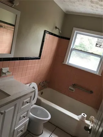 a bathroom with a toilet a sink and a mirror