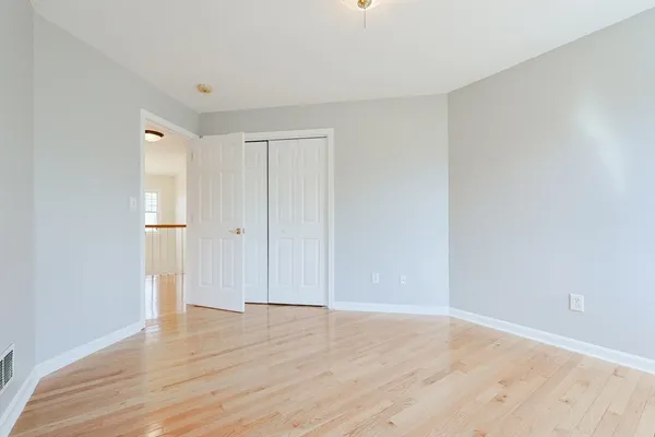 a view of empty room with wooden floor and entryway