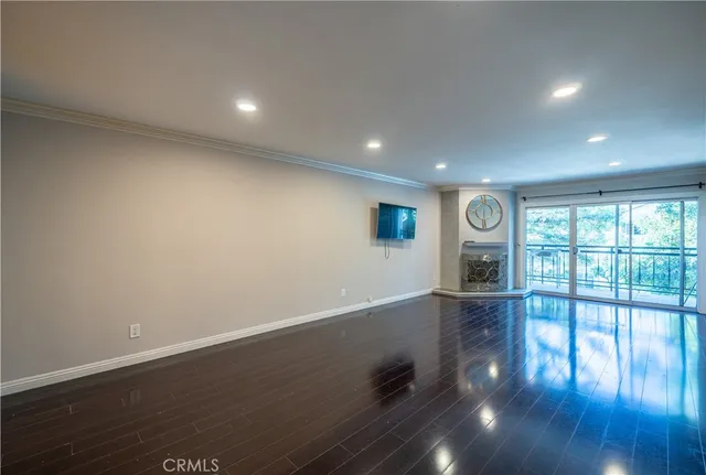 an empty room with wooden floor and glass door