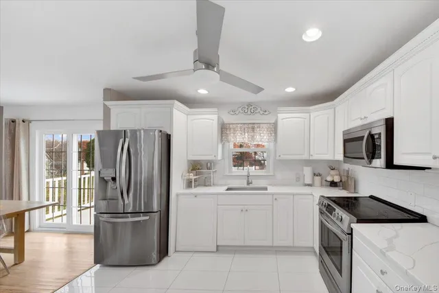 a kitchen with stainless steel appliances granite countertop a sink and a refrigerator
