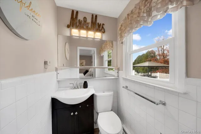 a bathroom with a granite countertop sink mirror and a toilet