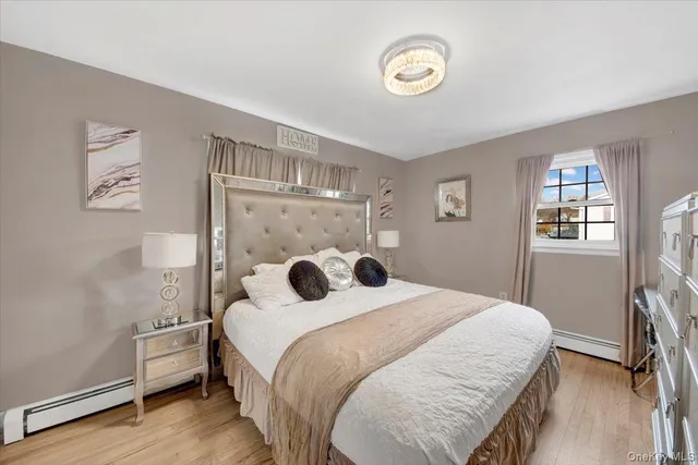 a bedroom with a large bed and a flat tv screen on dresser