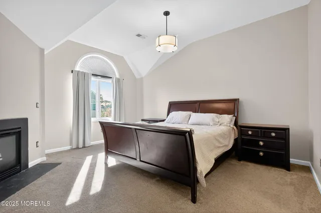 a spacious bedroom with a bed and a chandelier