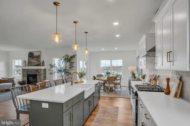 a large kitchen with lots of counter space a sink appliances and living room view