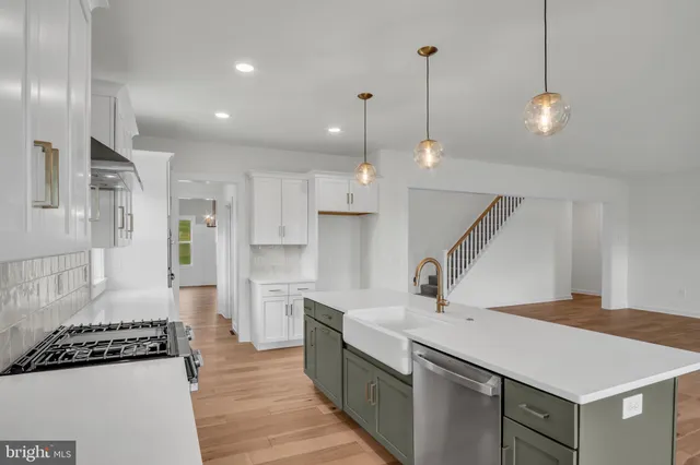 a kitchen with stainless steel appliances granite countertop a sink a refrigerator and a stove