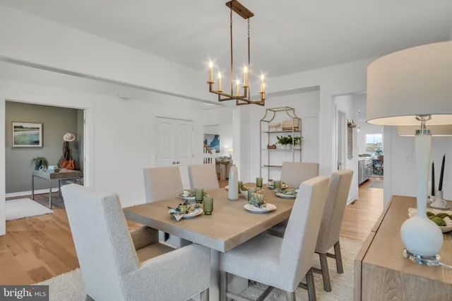 a view of a dining room with furniture a chandelier and wooden floor