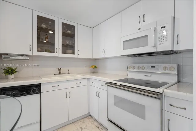 a kitchen with white cabinets and white appliances