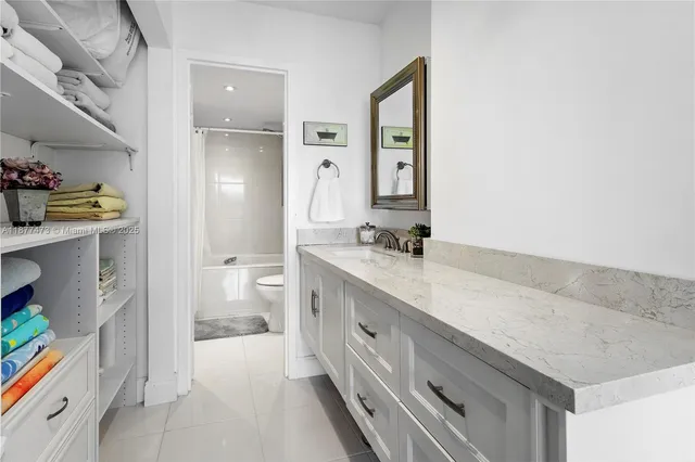 a spacious bathroom with a granite countertop sink and a mirror