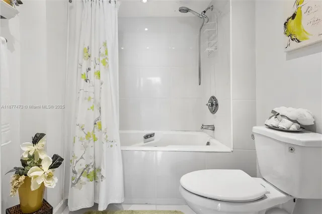 a white toilet sitting next to a bathroom sink and a shower
