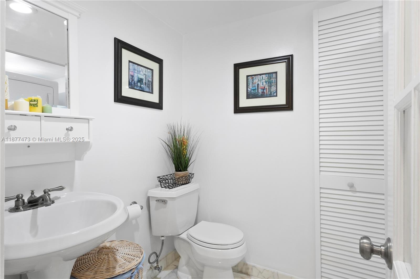 200 Southeast 15th Road, Unit 6F Miami, FL 33129 - Photo 32 of 38 a bathroom with a toilet a sink and a mirror