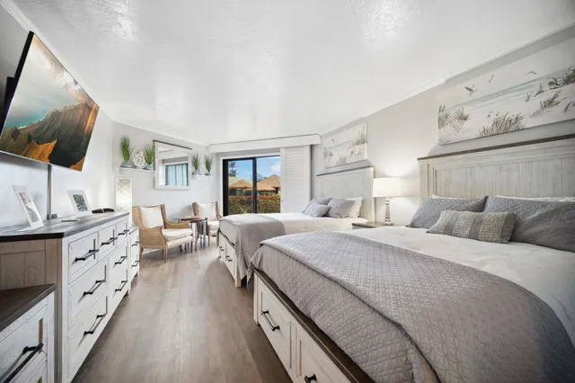 a bedroom with a large bed and a flat screen tv