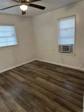 a view of empty room with wooden floor